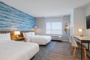 a hotel room with two beds and a desk at TownePlace Suites by Marriott Geneva at SPIRE Academy in Geneva