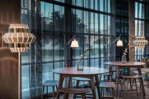 a row of tables and chairs in a room with windows at AC Hotel Firenze by Marriott in Florence