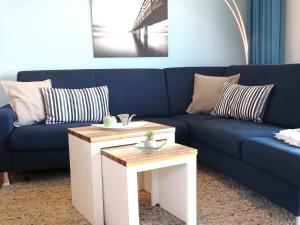a living room with a blue couch and a table at Gode Wind Quartiere 3 in Dahme
