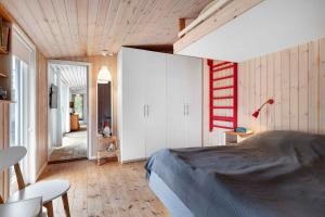 ein Schlafzimmer mit einem Bett und einer Holzdecke in der Unterkunft Charming Lovely Forest House in Hadsund