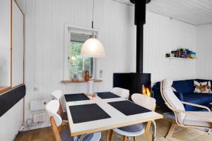 ein Esszimmer mit einem Tisch, Stühlen und einem Kamin in der Unterkunft Charming Lovely Forest House in Hadsund