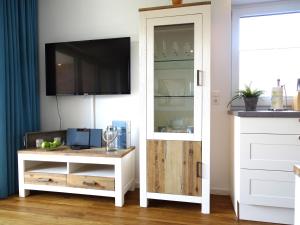 a living room with a tv and a white cabinet at Gode Wind Quartiere 3 in Dahme