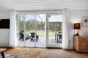 Zimmer mit einer Glasschiebetür und einer Terrasse in der Unterkunft Charming Lovely Forest House in Hadsund