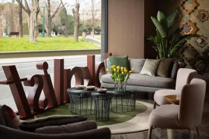een woonkamer met een bank en een tafel en stoelen bij Lokalist, Istanbul, a Tribute Portfolio Hotel in Istanbul