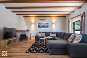 uma sala de estar com um sofá e uma televisão em Villa Moonlight by Abahana Villas em Benitachell