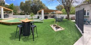 a backyard with a grill and a table and chairs at Les jardins de Funtanone T3 in Vignale