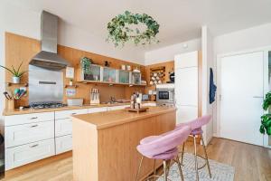 a kitchen with white cabinets and a pink stool at Luxury Huge Modern Open Plan 2Bedroom Flat - Free Private Parking & Balcony located at the OVO Hydro and SEC Centre in Glasgow