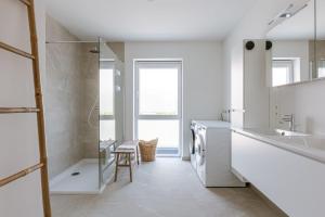 Un baño blanco con lavabo y ducha. en Huswell - Brand new house "Sable D'or" in Oostduinkerke, en Oostduinkerke 35 fotos más