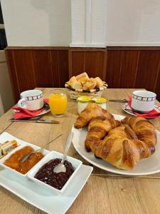 a table with a plate of croissants and a plate of bread at Ferme Auberge Ibarnia in Lecumberry