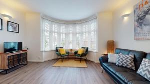 ein Wohnzimmer mit einem Sofa und einem Tisch in der Unterkunft 79 Chats in London