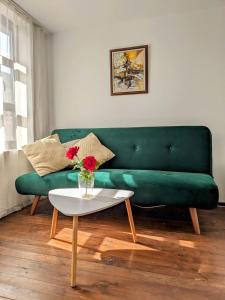 un sofá verde en una sala de estar con mesa en Honey I`m home Apartments, en Veliko Tŭrnovo
