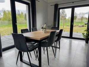 a dining room with a wooden table and chairs at Dom nad Selmętem in Mrozy Wielkie