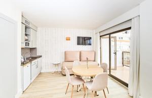 a kitchen and dining room with a table and chairs at Leonardo Royal Hotel Ibiza Santa Eulalia in Es Cana