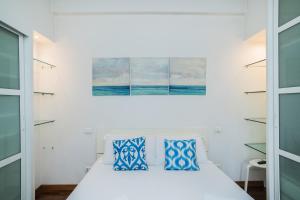 1 dormitorio con 1 cama con almohadas azules y blancas en Harry's Flat 38 en Roma