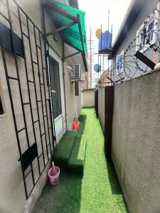 Un callejón con césped verde al costado de un edificio. en Graceville apartment, en Lagos 3 fotos más