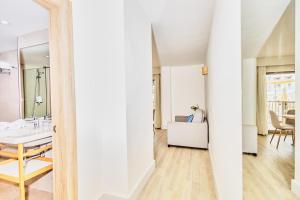 a living room with a table and a mirror at Leonardo Royal Hotel Ibiza Santa Eulalia in Es Cana