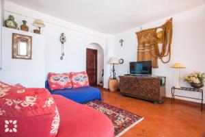 uma sala de estar com um sofá vermelho e uma televisão em Villa Timeris by Abahana Villas em Calpe