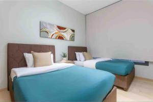 a bedroom with two beds and a painting on the wall at Luxurious Saifi 477, 2-BR Apt in Beirut