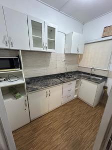 una cocina vacía con armarios blancos y fregadero en Graceville apartment, en Lagos
