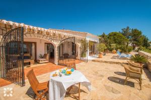 a patio with a table and chairs and a house at Villa Timeris by Abahana Villas in Calpe