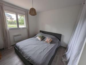 una camera da letto con un letto con due cuscini sopra di Jolie maison au pied du Vercors a Bourg-de-Péage