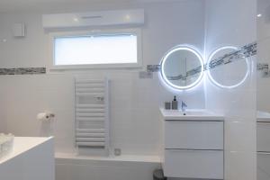 ein weißes Badezimmer mit Waschbecken und Fenster in der Unterkunft LOFT COZY 77 CONFORT Terrasse - Free Parking - Wifi - 3 CH et 2 SDB - Aéroport CDG - Disneyland Paris in Annet-sur-Marne