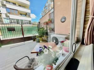 Un balcón con una mesa con flores. en White Rose Guest Rooms, en Burgas