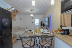 a kitchen with a table and two bar stools at --OFFRE SPECIALE-- LOFT COZY 77 --NEW--Jaccuzi CONFORT Terrasse Parking Wifi - 3 CH et 2 SDB - Aéroport CDG - Disneyland Paris in Annet-sur-Marne