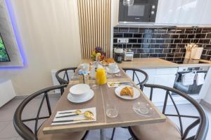 a table with plates of food on it in a kitchen at --OFFRE SPECIALE-- LOFT COZY 77 --NEW--Jaccuzi CONFORT Terrasse Parking Wifi - 3 CH et 2 SDB - Aéroport CDG - Disneyland Paris in Annet-sur-Marne