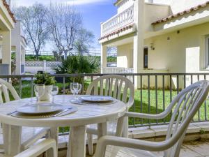 a white table and chairs on a patio at Apartment Muga-2 by Interhome in Empuriabrava