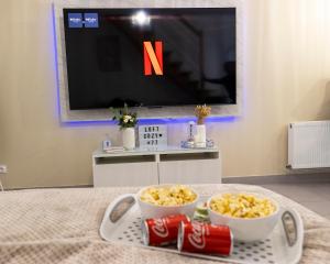 a tray with two bowls of coke and a television at --OFFRE SPECIALE-- LOFT COZY 77 --NEW--Jaccuzi CONFORT Terrasse Parking Wifi - 3 CH et 2 SDB - Aéroport CDG - Disneyland Paris in Annet-sur-Marne