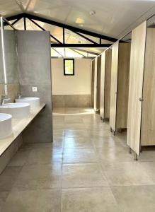 a large bathroom with two sinks and two toilets at Camping El Madroñal in Fuenteheridos