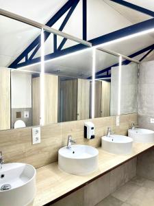 a bathroom with three sinks and a large mirror at Camping El Madroñal in Fuenteheridos