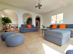 a living room with blue couches and orange pillows at Villa Atardecer by Interhome in Torrox Costa