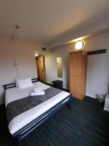 ロンドンにあるKabannas London St Pancrasの大きなベッドとドアが備わるホテルルームです。
