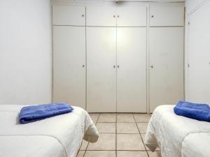 two beds in a room with white cabinets at Apartment Muga-2 by Interhome in Empuriabrava