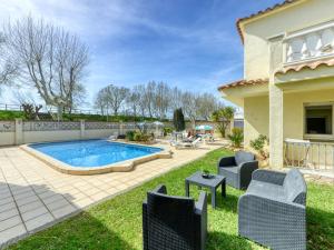 a backyard with a pool and chairs and a house at Apartment Muga-2 by Interhome in Empuriabrava