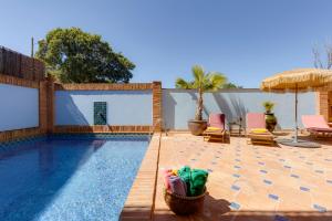 a swimming pool with two lawn chairs and a patio at Casa da Moura in Lagos