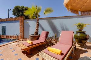 two chairs and a palm tree on a patio at Casa da Moura in Lagos