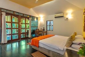 a bedroom with a bed and a desk in a room at The Bay Agonda in Agonda