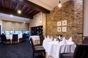 a dining room with tables and chairs and a brick wall at Les Tanneurs in Namur