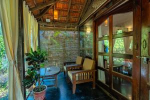 a screened in porch with a table and chairs at The Bay Agonda in Agonda