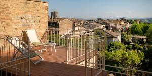 Un balcón con dos sillas y vista a una ciudad. en Appartamento Le Palme con terrazze in centro, en San Gimignano 10 fotos más