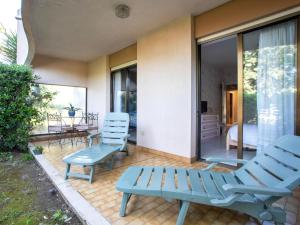 a patio with two blue chairs and a table at Apartment Marines de Villeneuve by Interhome in Villeneuve-Loubet