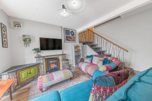 a living room with two blue couches and a fireplace at Blue Sky Cottage in Keswick