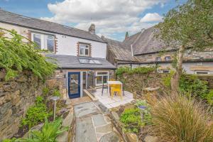 an exterior view of a house with a stone wall at Blue Sky Cottage in Keswick