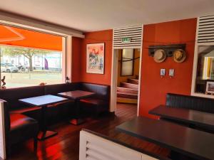 een restaurant met rode muren en tafels en banken bij Hotel Cap D'Ambre in La Barre-de-Monts