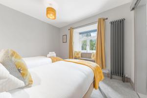 two beds in a room with a window at Blue Sky Cottage in Keswick