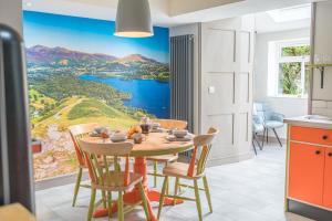a kitchen with a table with a view of the water at Blue Sky Cottage in Keswick
