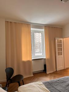 a bedroom with a bed and a window and a chair at Apartament przy Łazienkach Królewskich in Warsaw